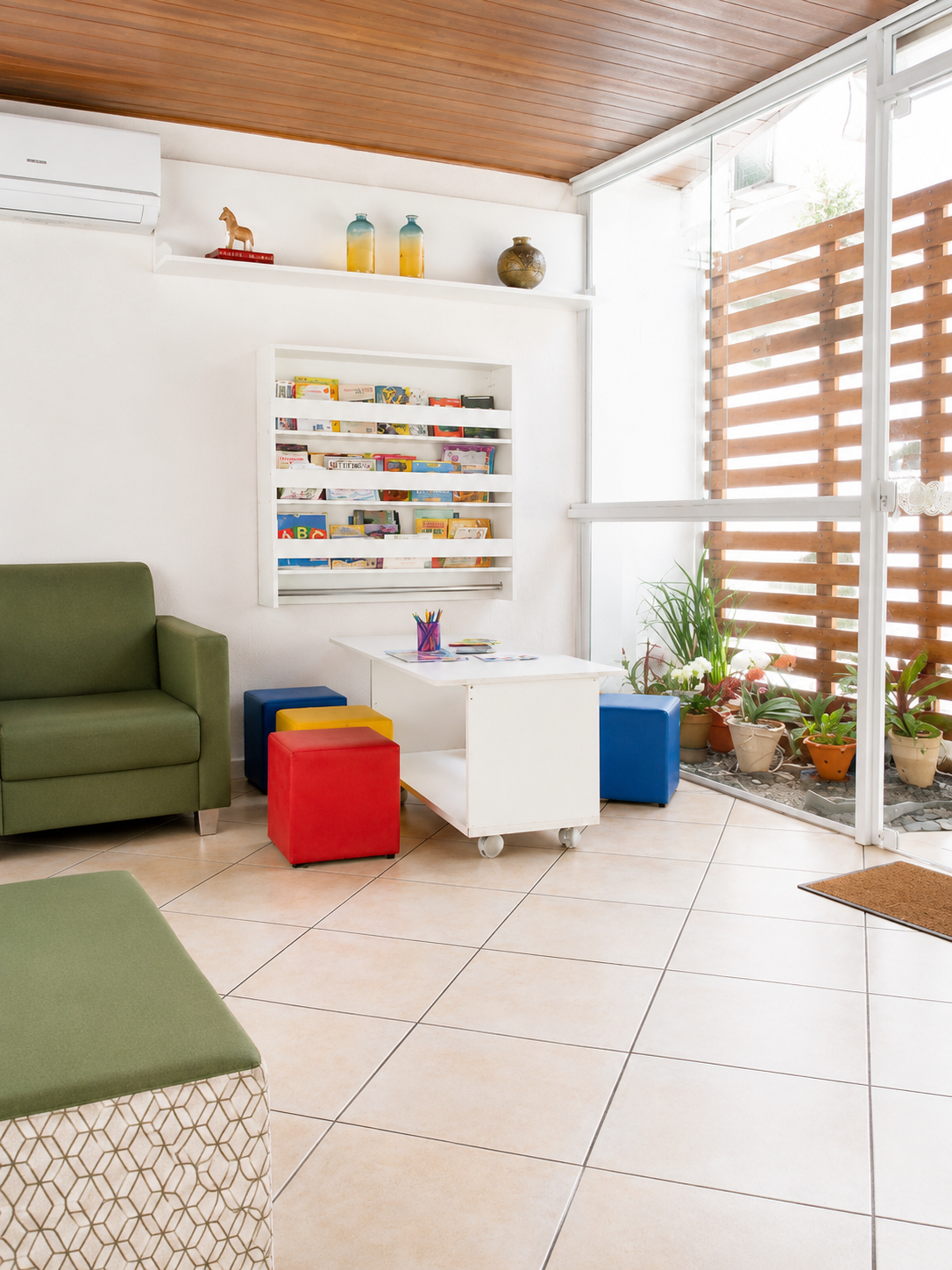 Espaço terapêutico infantil com livros, mesa e materiais de atendimento
